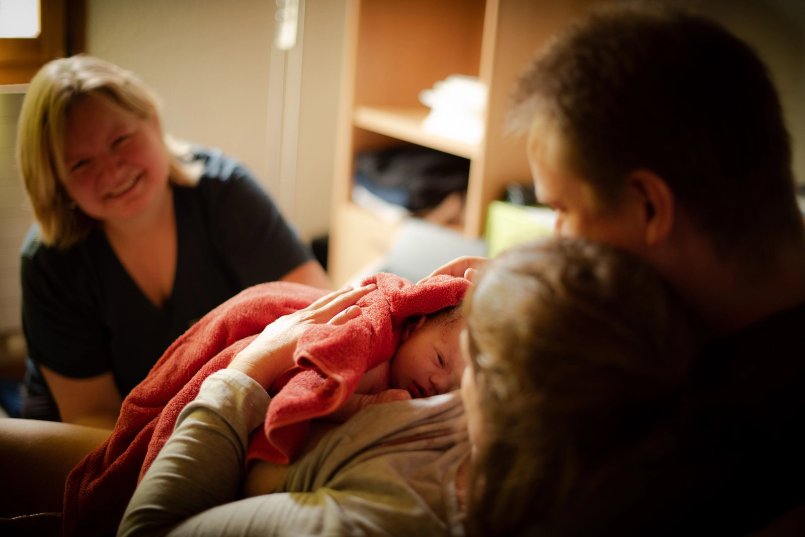 Neugeborenes liegt auf dem Bauch der Mutter nach der Hausgeburt