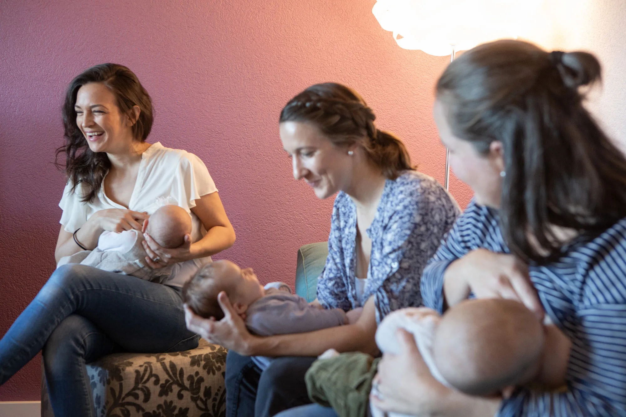 Drei Frauen nebeneinander sind ihre Babys am stillen beim Stilltreffen