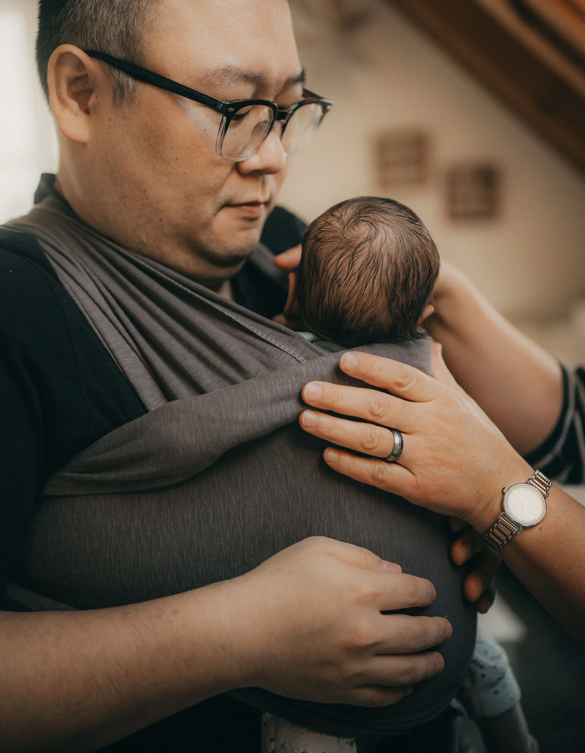 Vater hält Baby im Tragetuch
