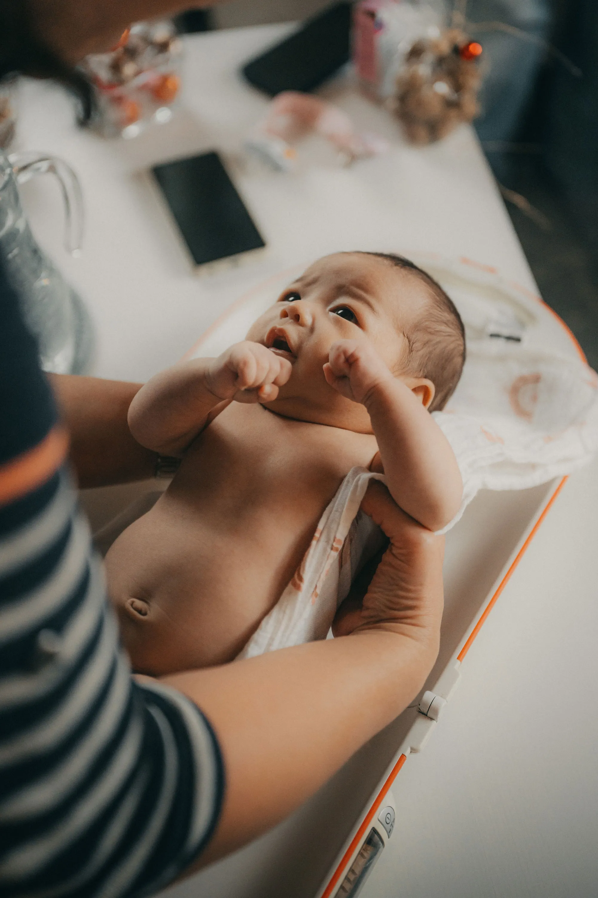 Nacktes Baby wird von einer Person in einem Tuch gehalten