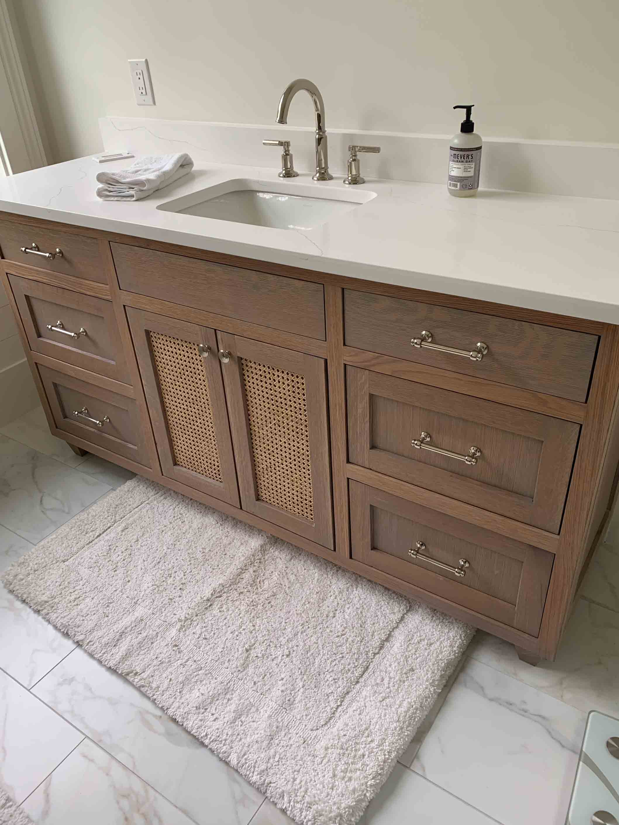 Custom stained white oak bathroom vanity with cane doors and tailored drawers