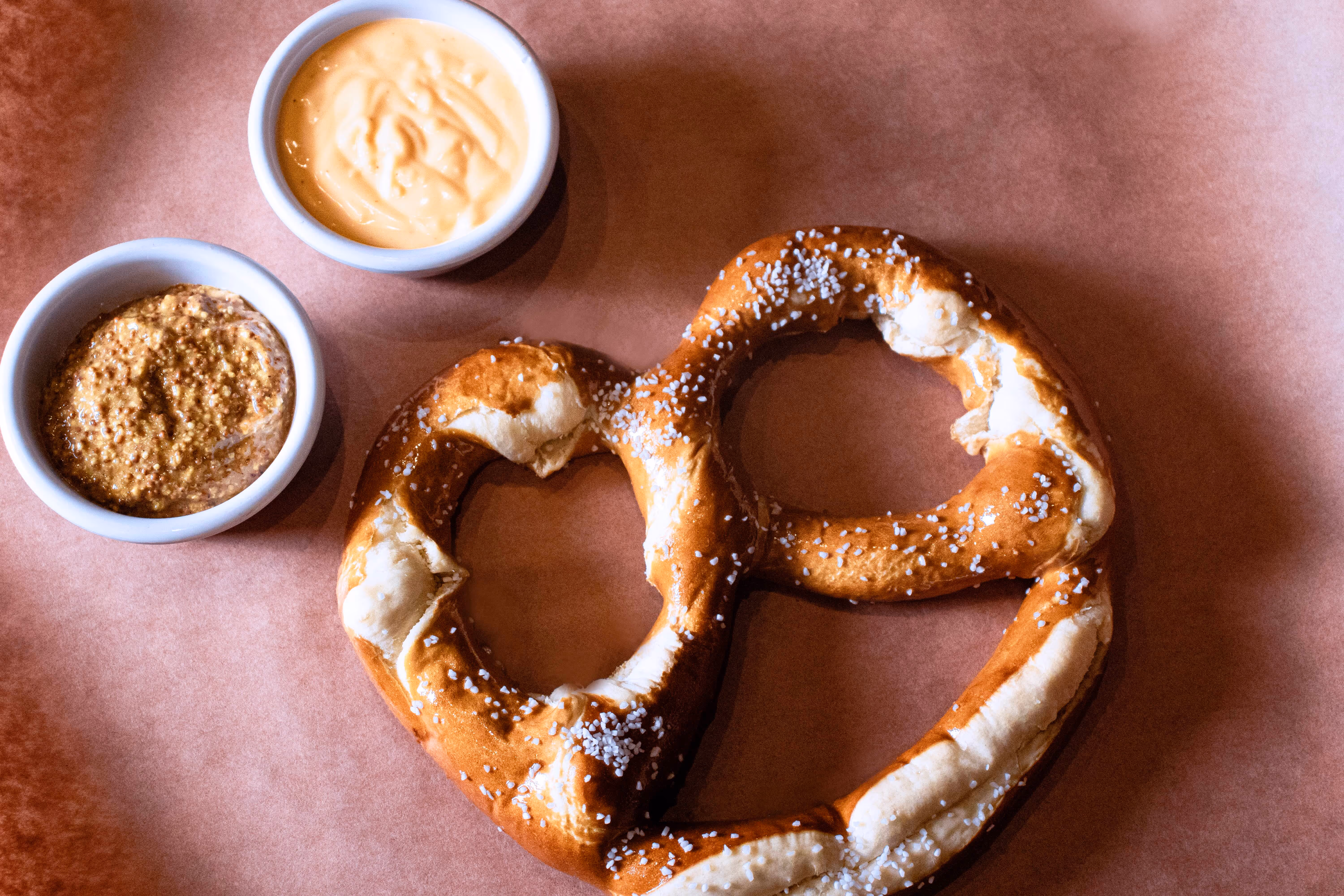 Oversized house-made soft pretzel from Old Route 69 Brewery in Ada, Ohio, served warm and topped with coarse salt, paired with tangy brown mustard for dipping.