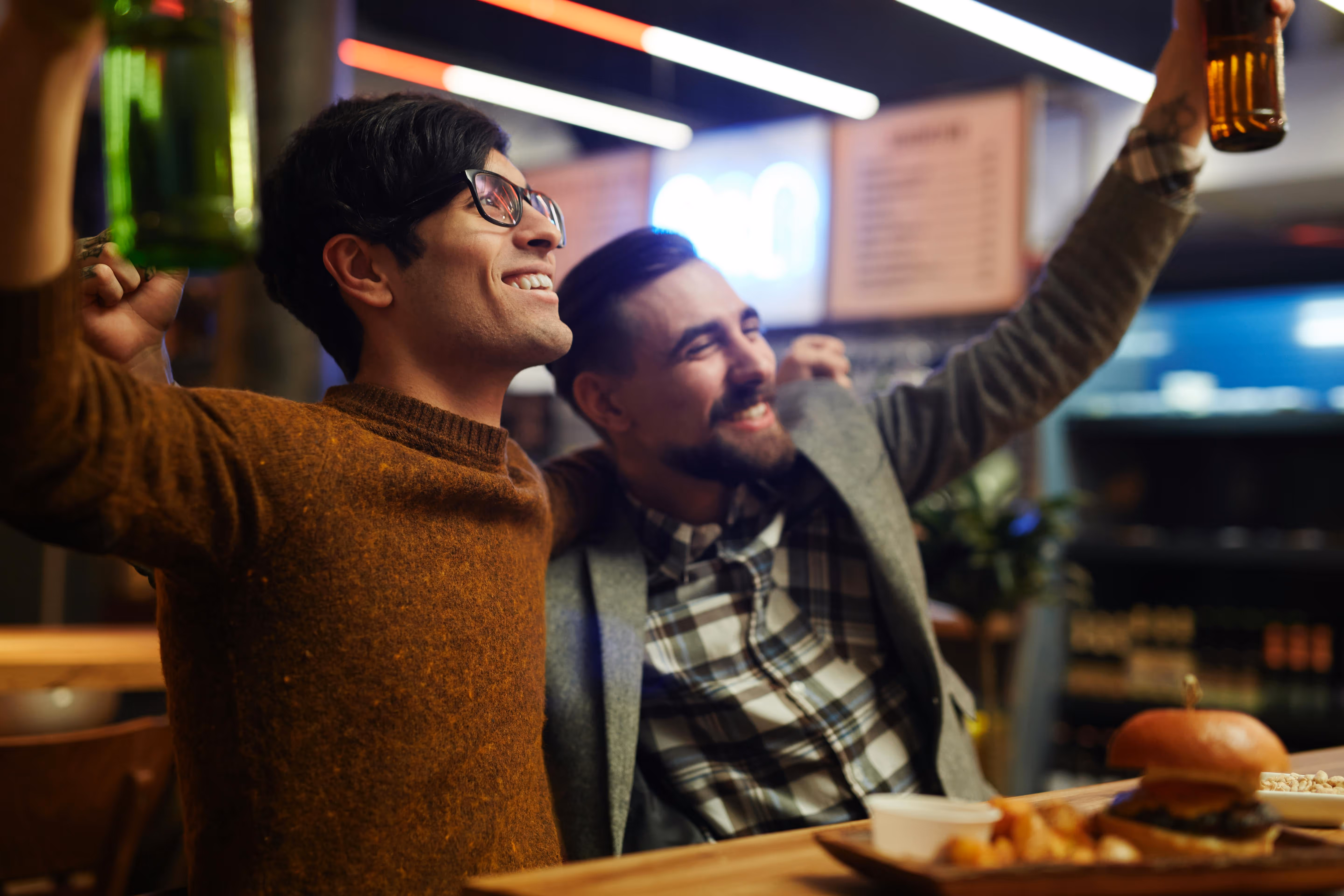 Two friends enjoying craft beer and fresh food at the bar of Old Route 69 Brewery in Ada, Ohio, showcasing a lively and welcoming atmosphere.