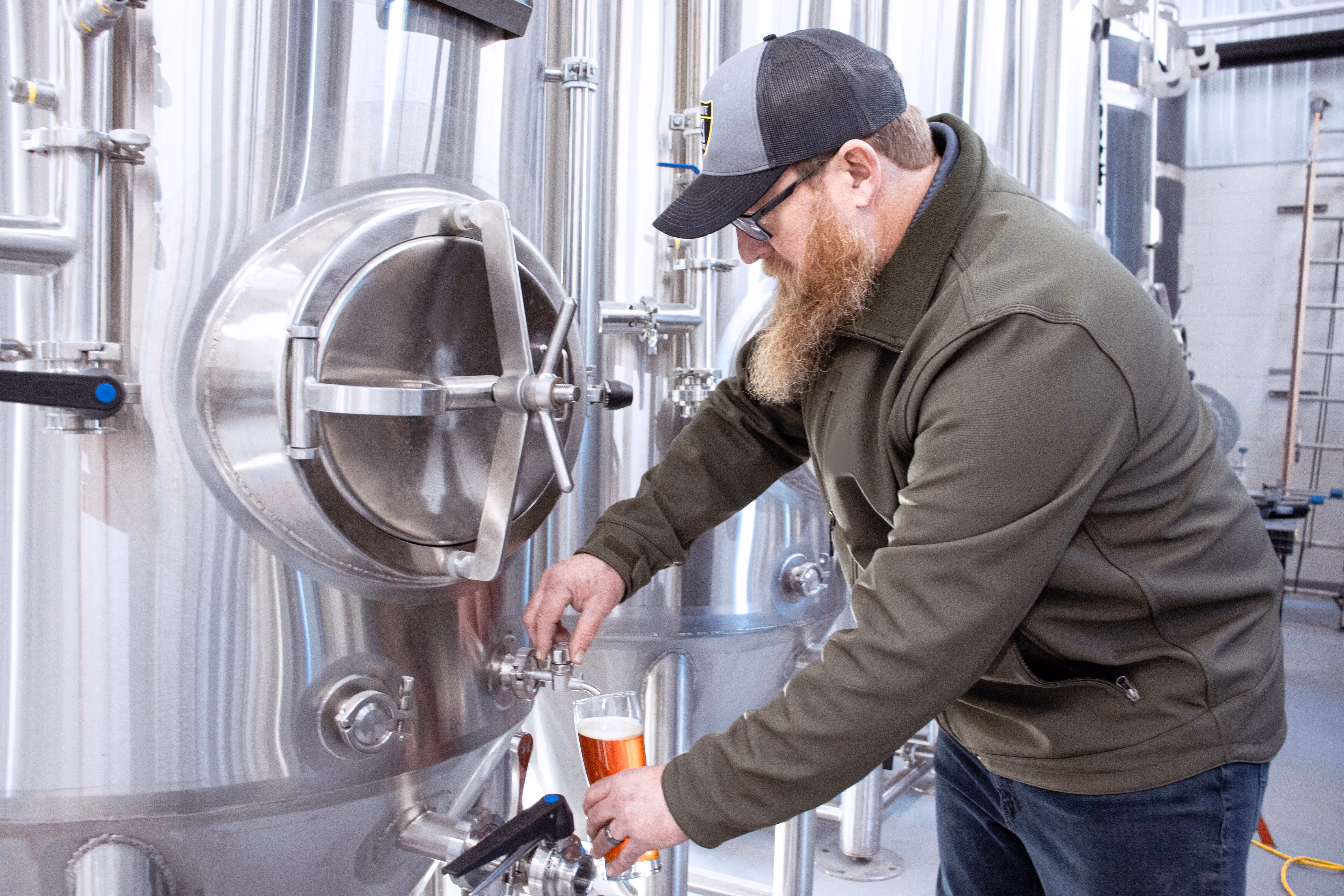 Head brewer John pouring a fresh draft of Old Route 69 craft beer straight from the brewing tank at the Ada, Ohio brewery.