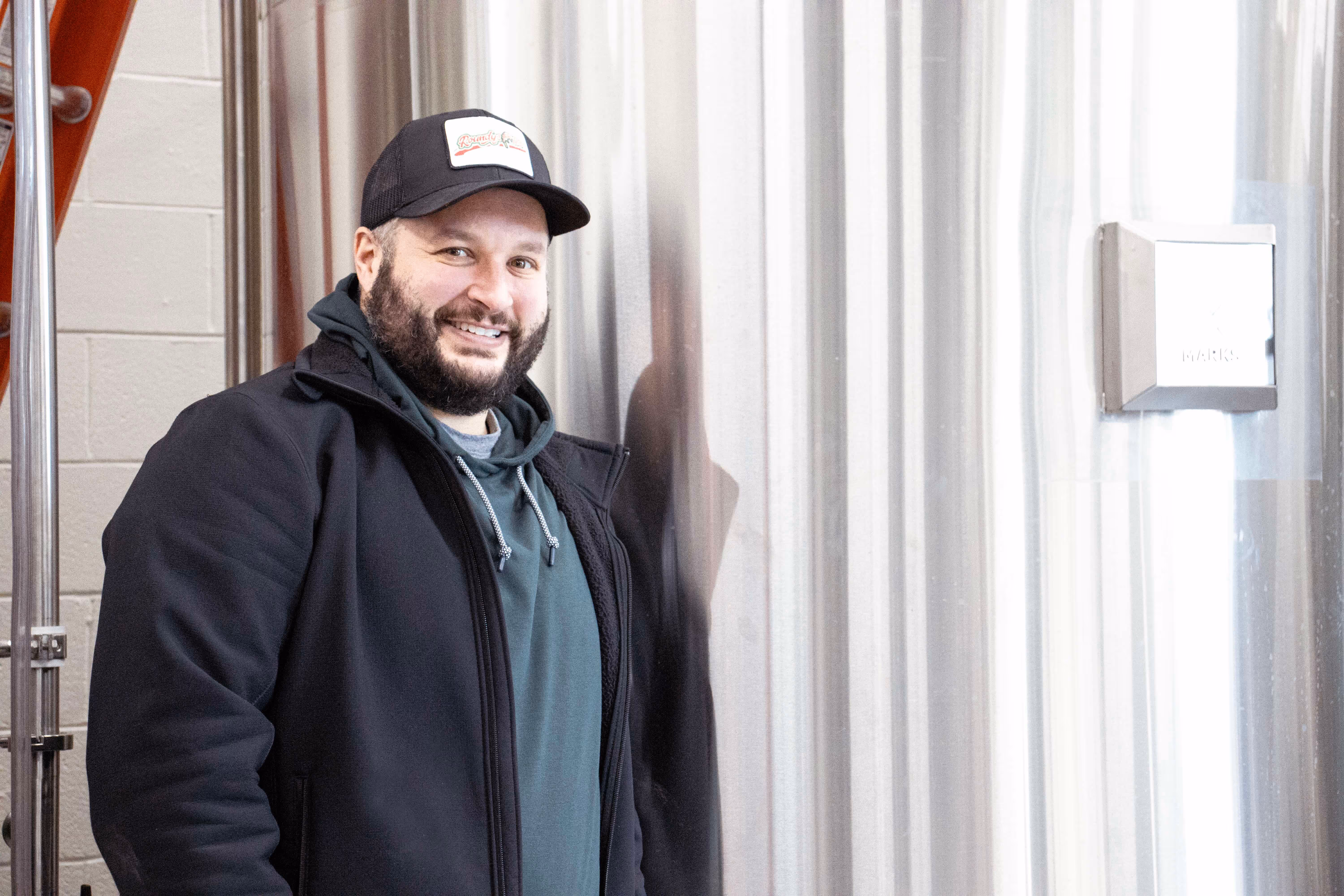Michael Allen, Head Cook at Old Route 69 Brewery, standing next to a brewing tank inside the brewery in Ada, Ohio.