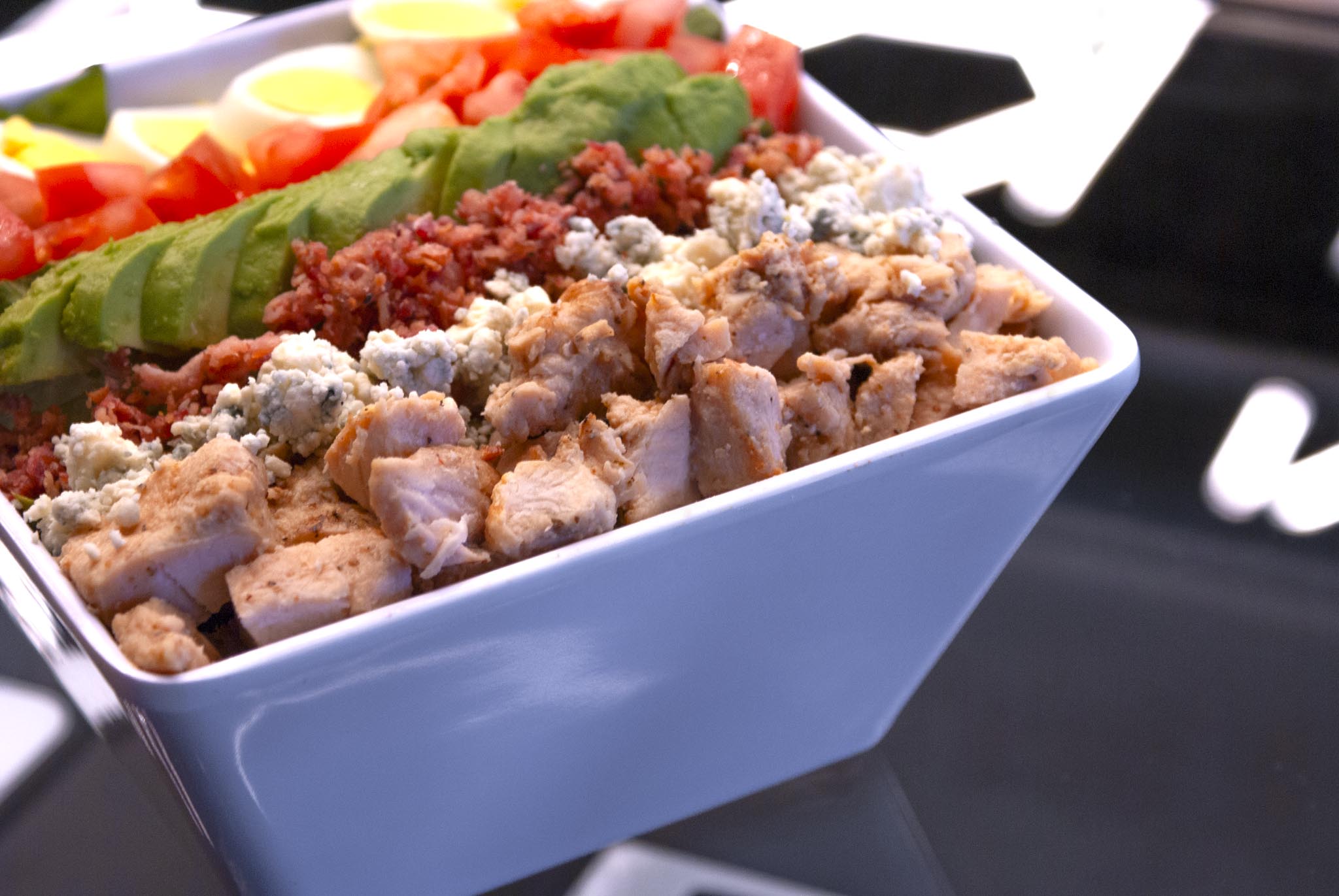 A fresh cobb salad with chicken in a bowl
