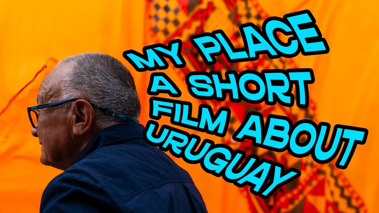 man in front of orange fabric with text surrounding is head