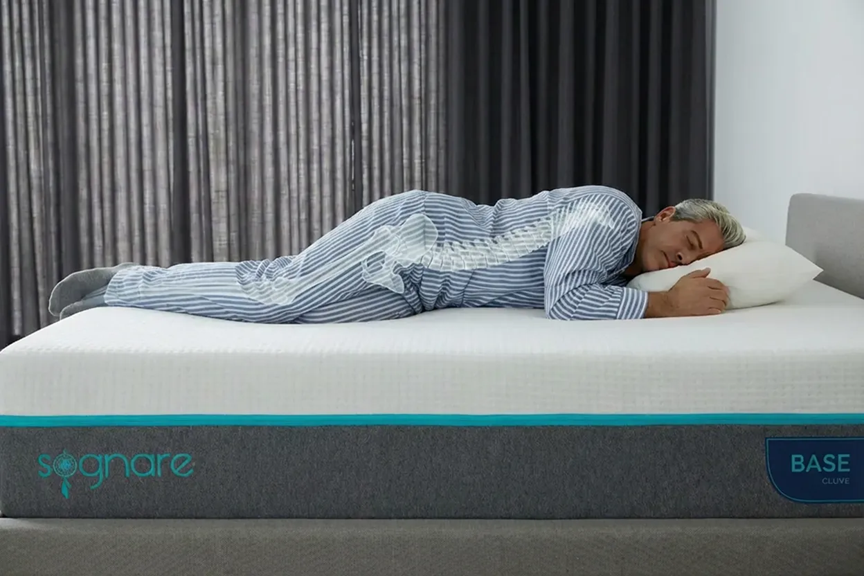 Persona durmiendo de lado en posición fetal sobre colchón Sognare Base mostrando adaptación de espuma a hombros y cadera