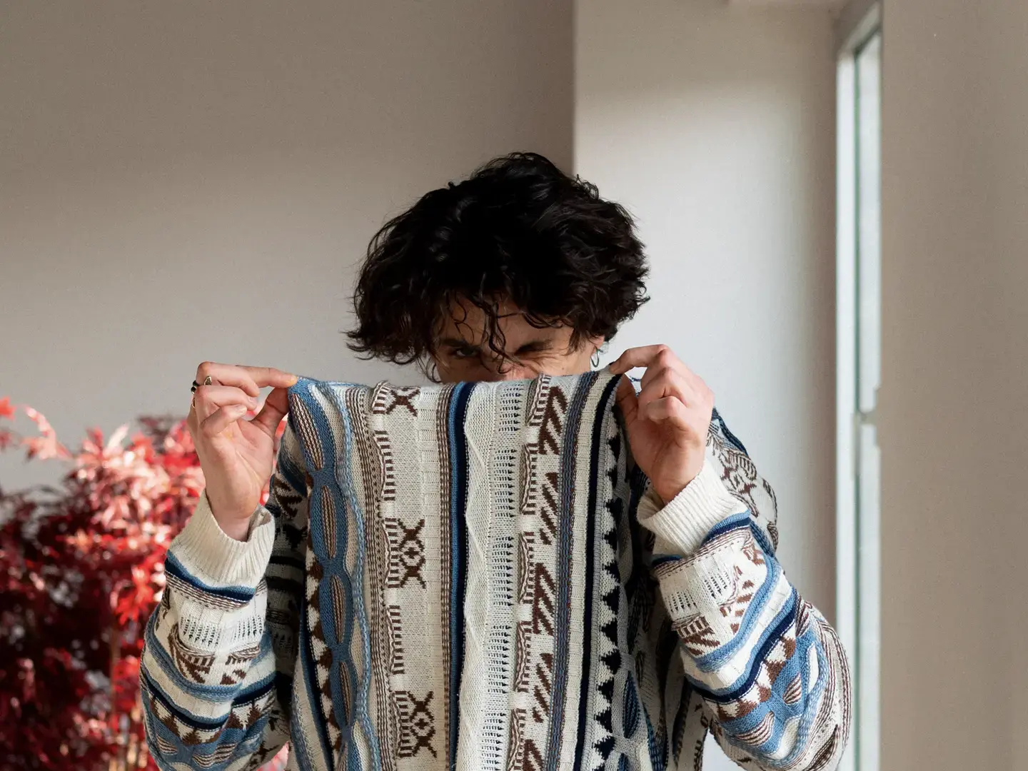 Miguel macht eine Grimasse und zieht seinen Pullover über Mund und Nase.