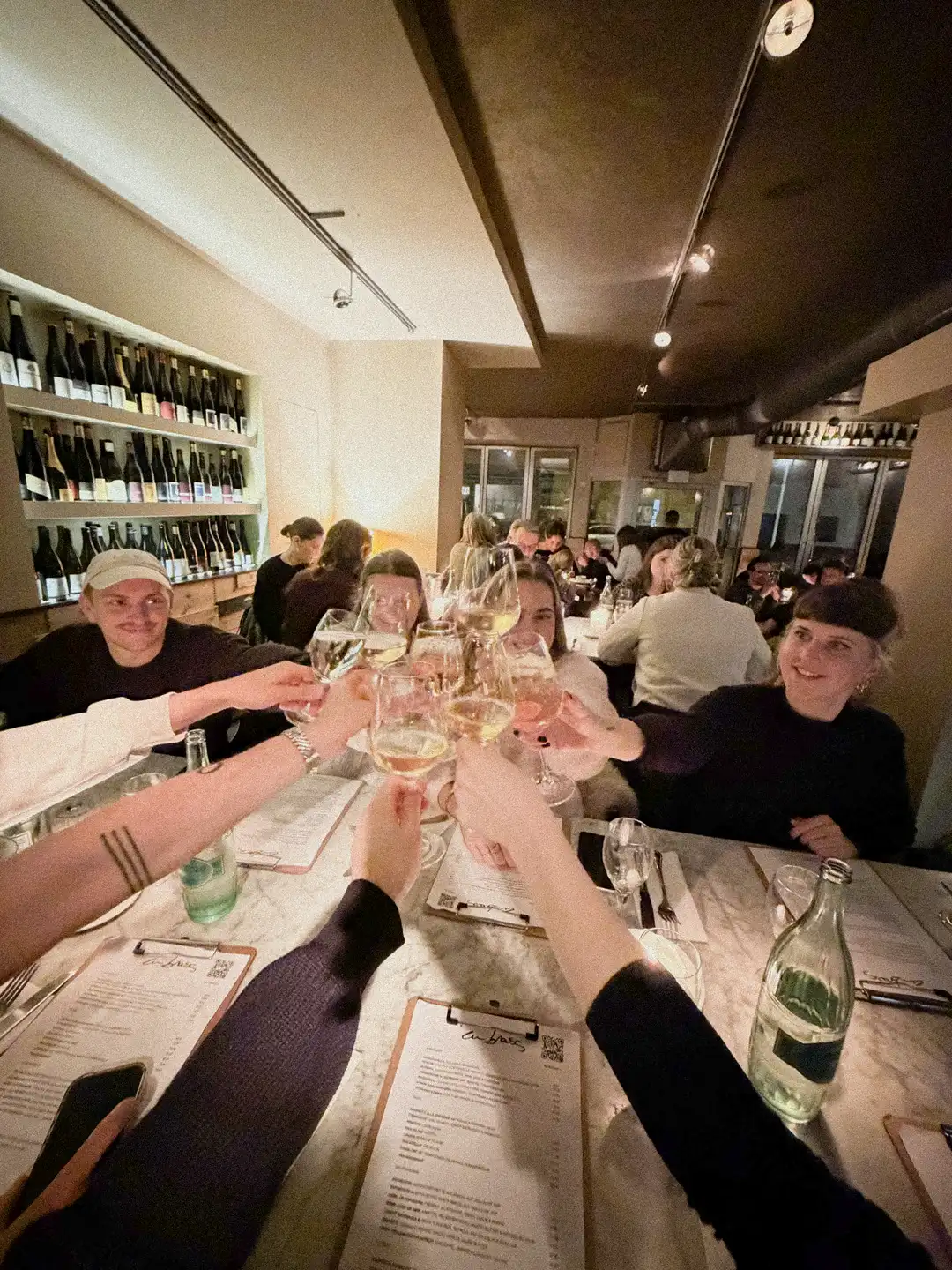 Unser Team feiert ein erfolgreiches Jahr 2025 und stößt die Weingläser im Restaurant an.