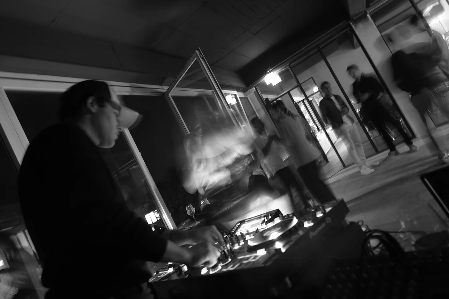 Over the shoulder of a DJ at a party in the office.