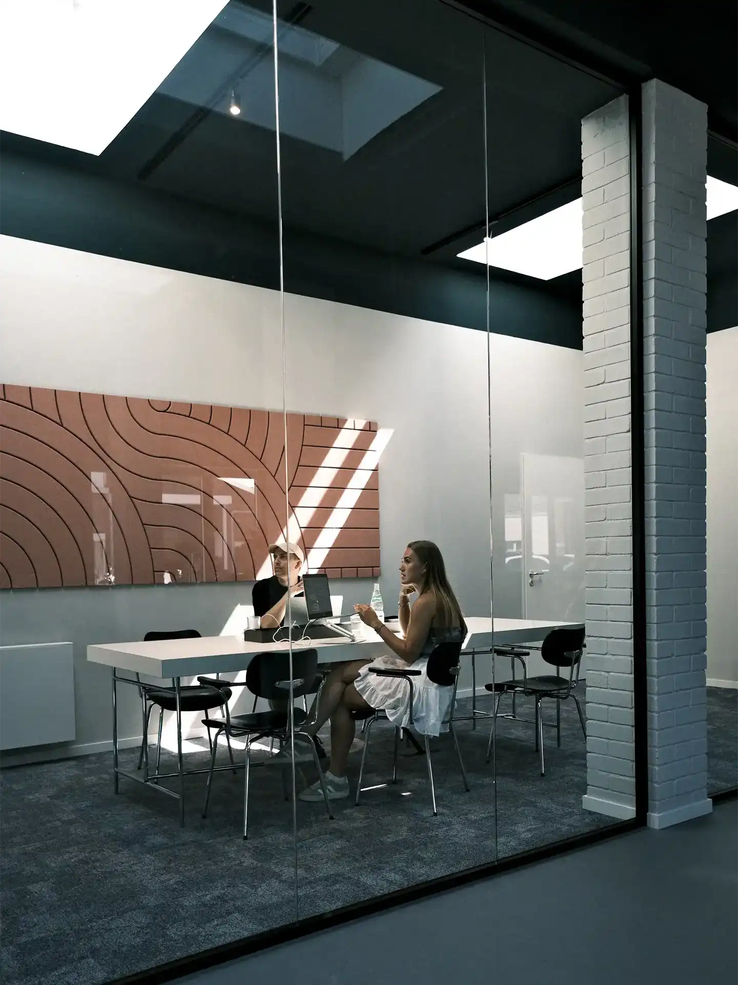 Two people sitting inside a large meeting room during an onboarding session.