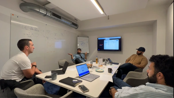 Bonanza team holding a workshop in person. This image show 4 male individuals in a conference room.