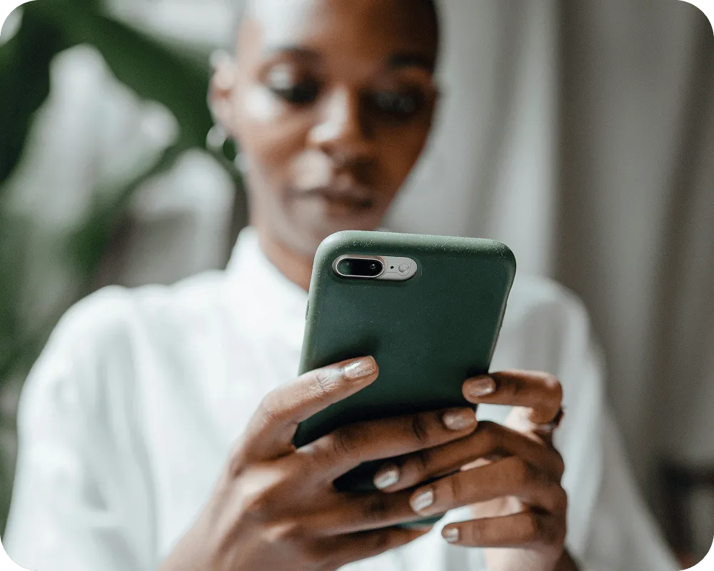 Person and looking at a smartphone with a green case.