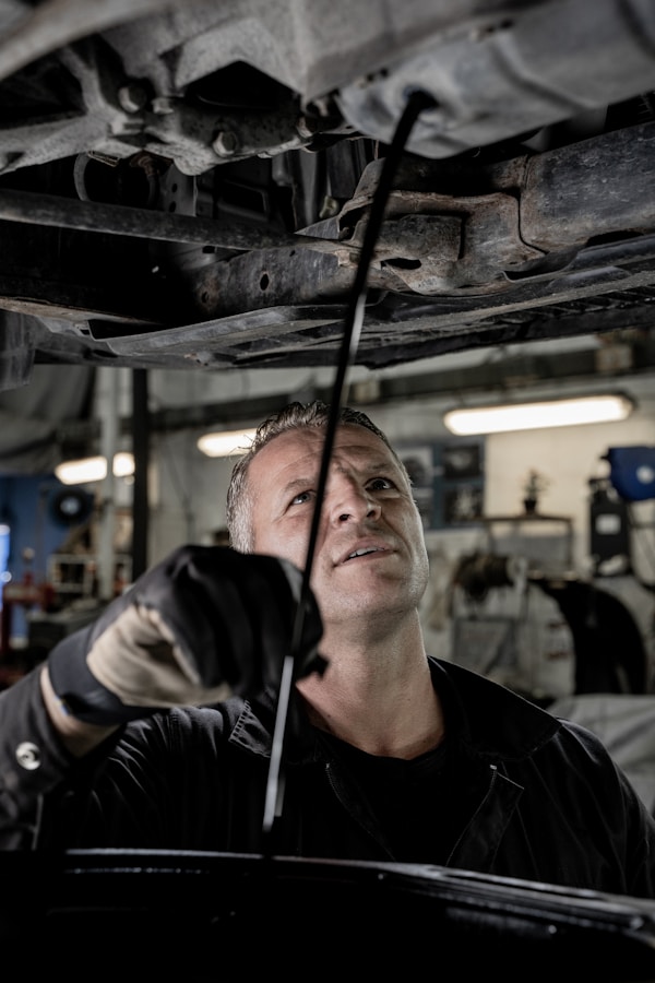A mechanic changes oil in a car.