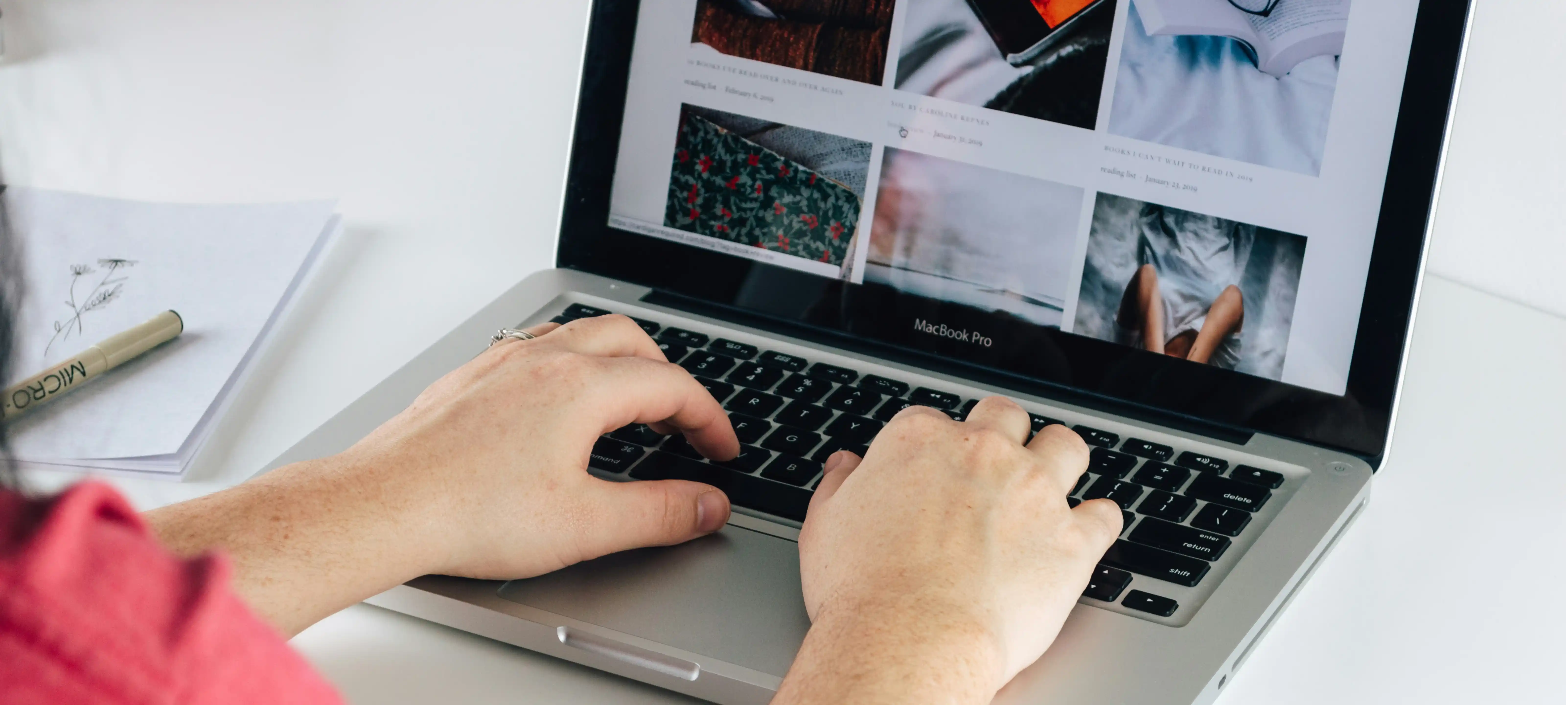 Person verwaltet digitale Hotelinhalte am Laptop.