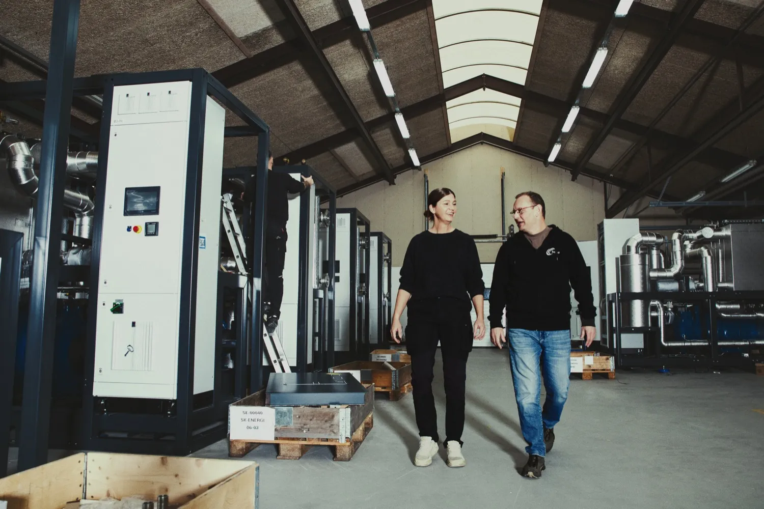 Two employees in Solid Energy's production hall with heat pumps