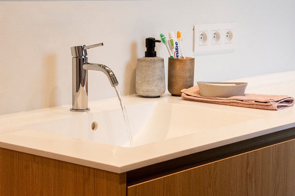 Lopende kraan in een badkamer, geïnstalleerd door Sanville