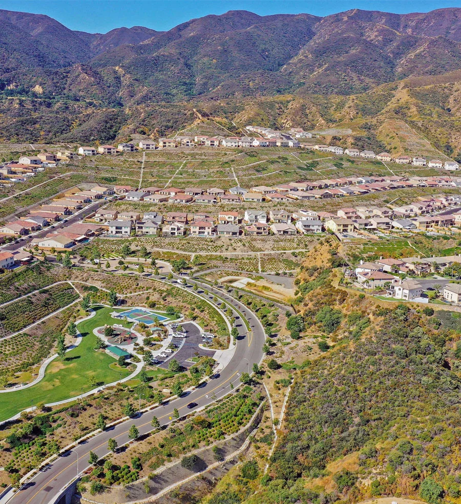 Master planning projects: aerial view of a housing development and park below hills