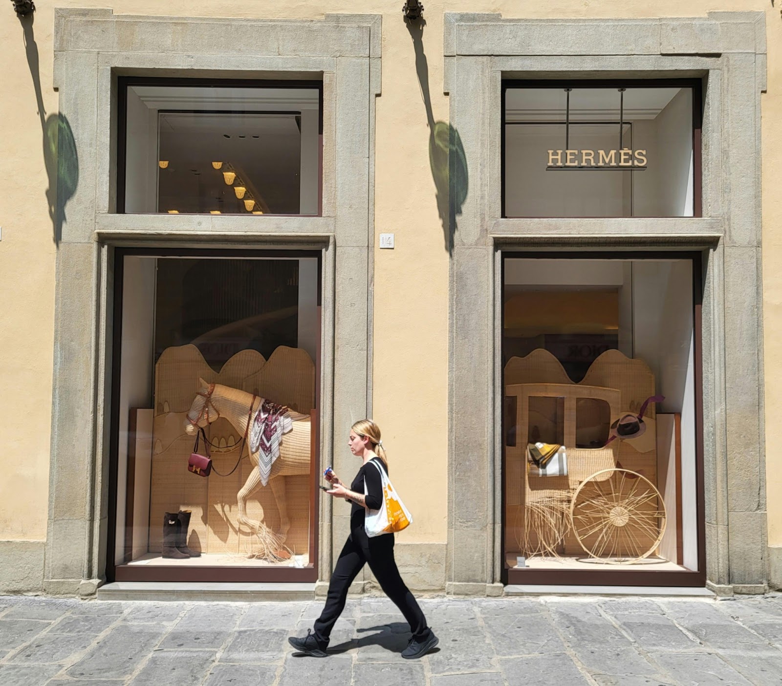 A woman is walking in front of Hermes store