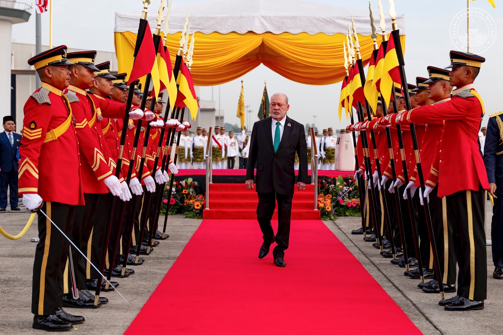 KDYMM Seri Paduka Baginda Yang di-Pertuan Agong Sultan Ibrahim wallking on red carpet with the armies besides him.