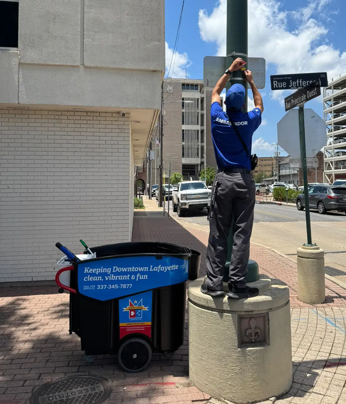 A Downtown Ambassador fixes a sign