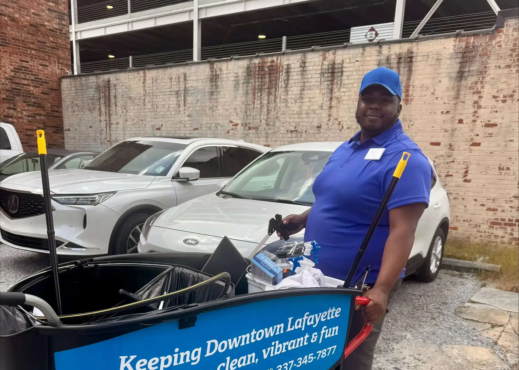 A downtown ambassador stands with a cart for cleaning up downtown