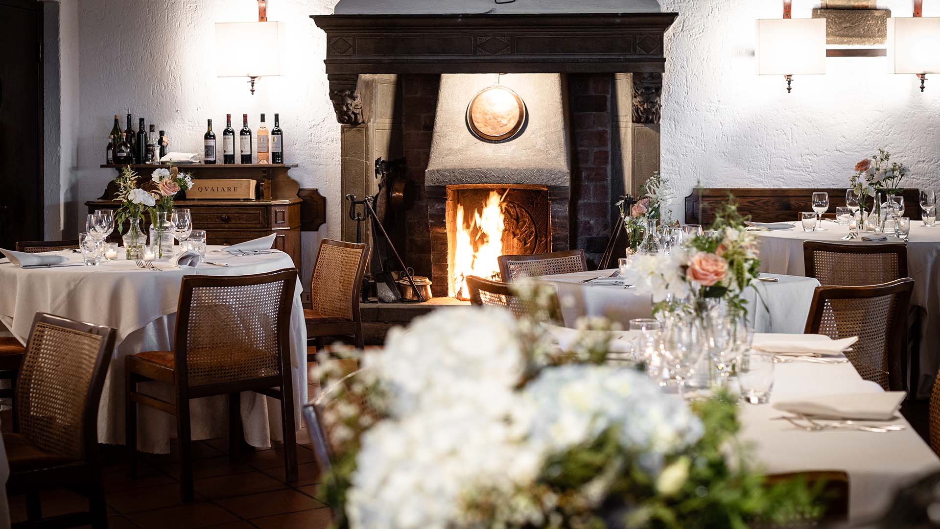 Vista di della sala interna del ristorante  con focus  sul camino acceso
