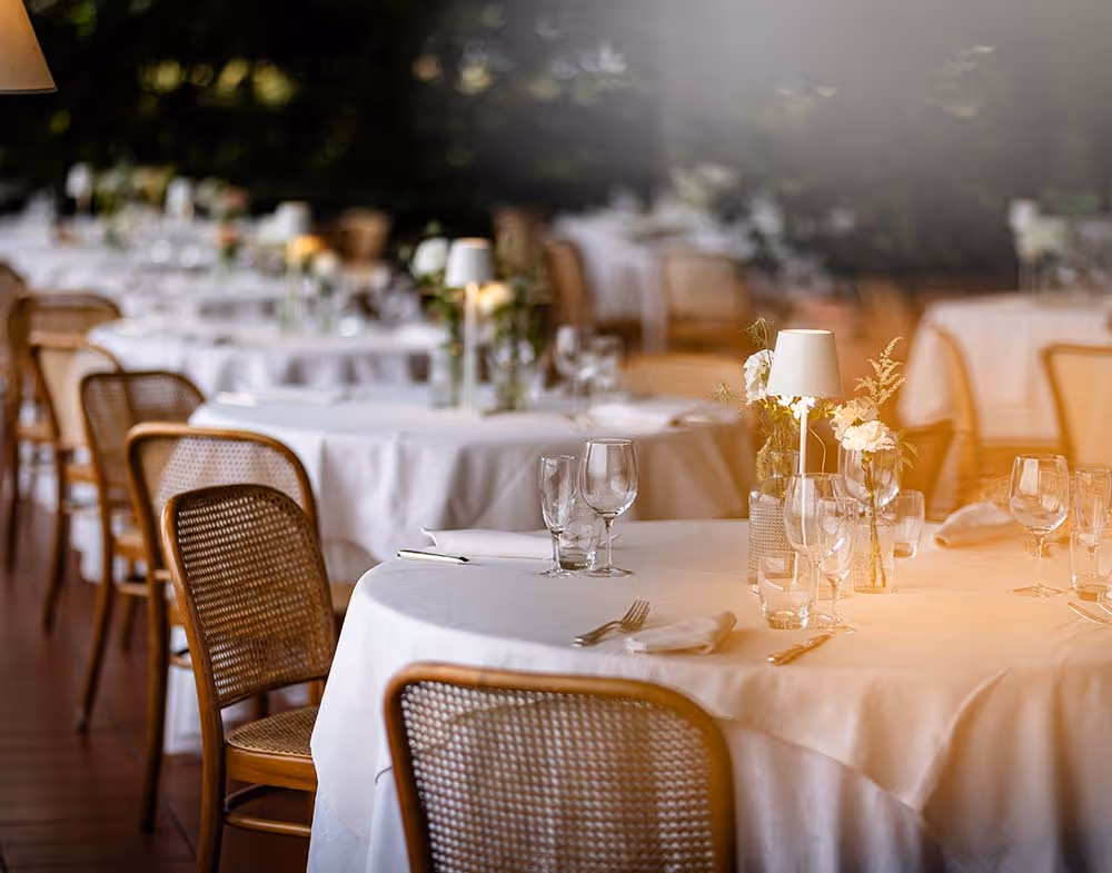 Tavolo apparecchiato elegantemente con tovaglia bianca e calici di vino in ristorante a Bergamo