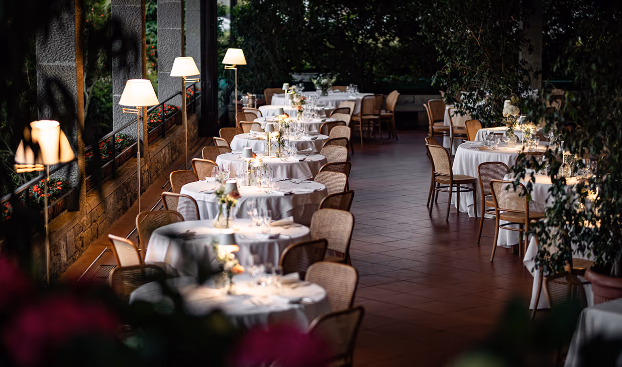 Tavolo apparecchiato elegantemente con tovaglia bianca e calici di vino in ristorante a Bergamo