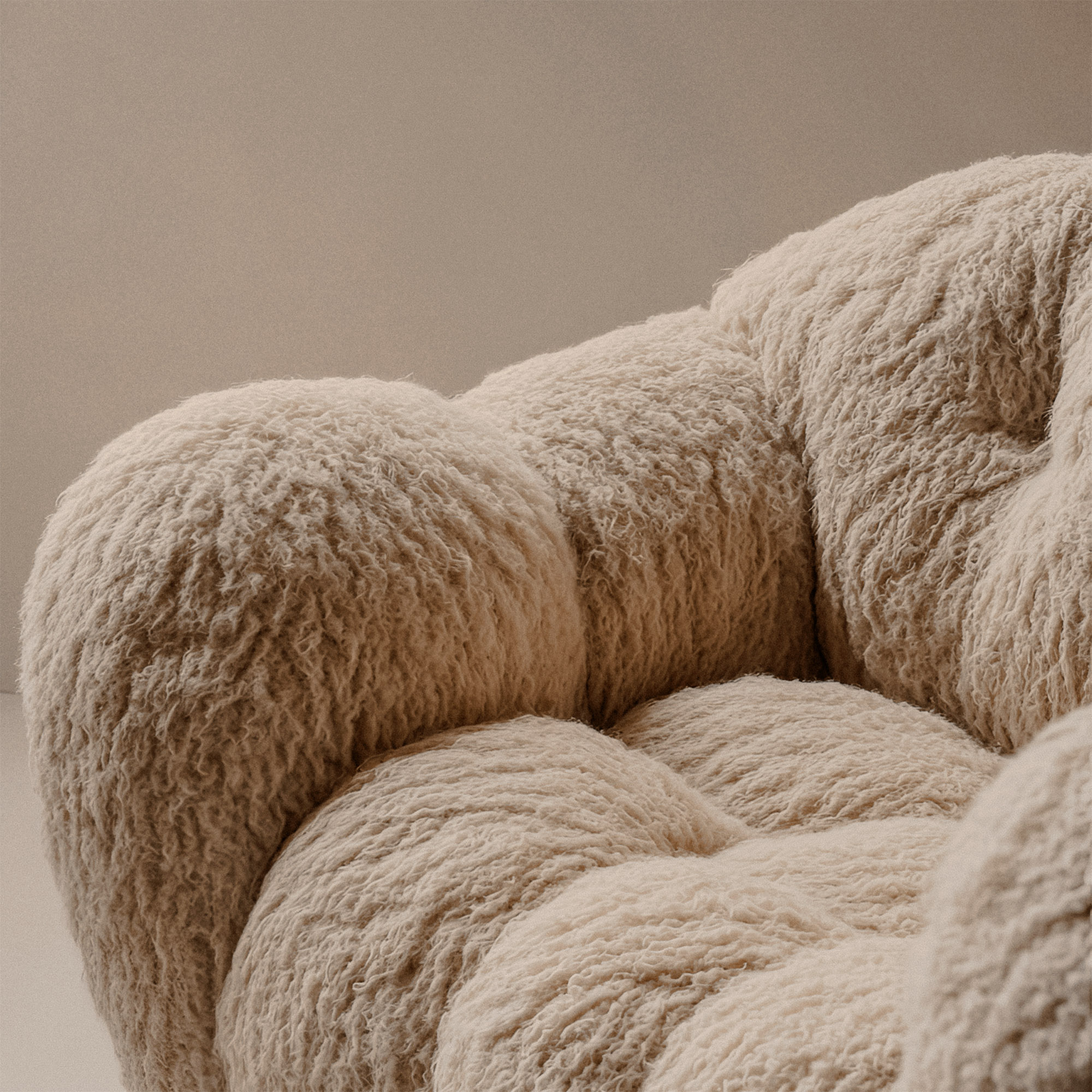 Close-up of plush designer armchair with shaggy boucle wool texture in beige — luxurious modern furniture detail for cozy and tactile interior design