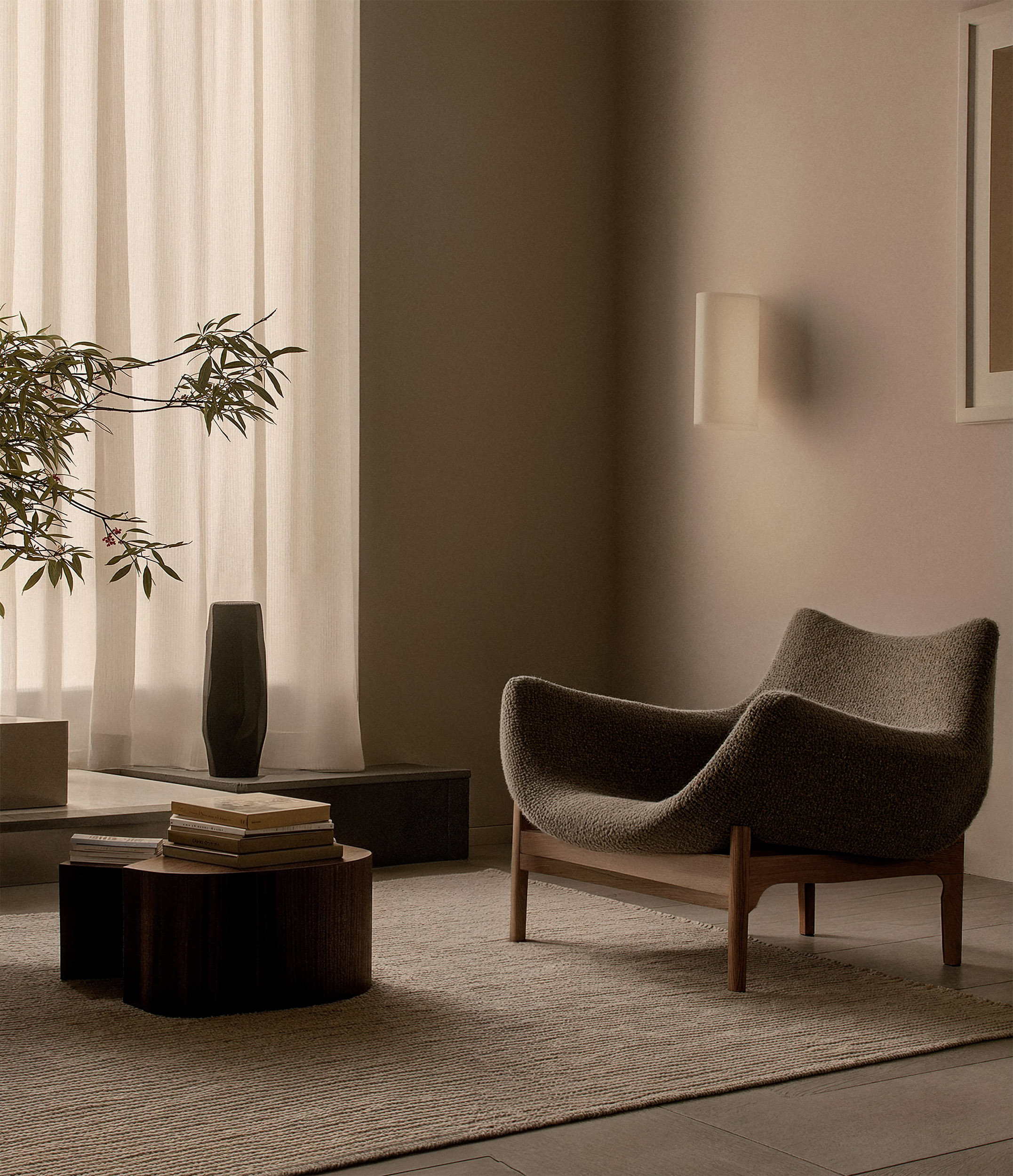 Modern cozy reading corner with textured lounge chair, low wooden coffee table and neutral interior tones — minimalist interior design for serene living spaces