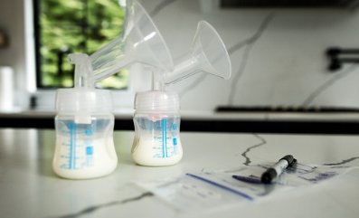 breast pump setup with filled milk bottles and storage bags