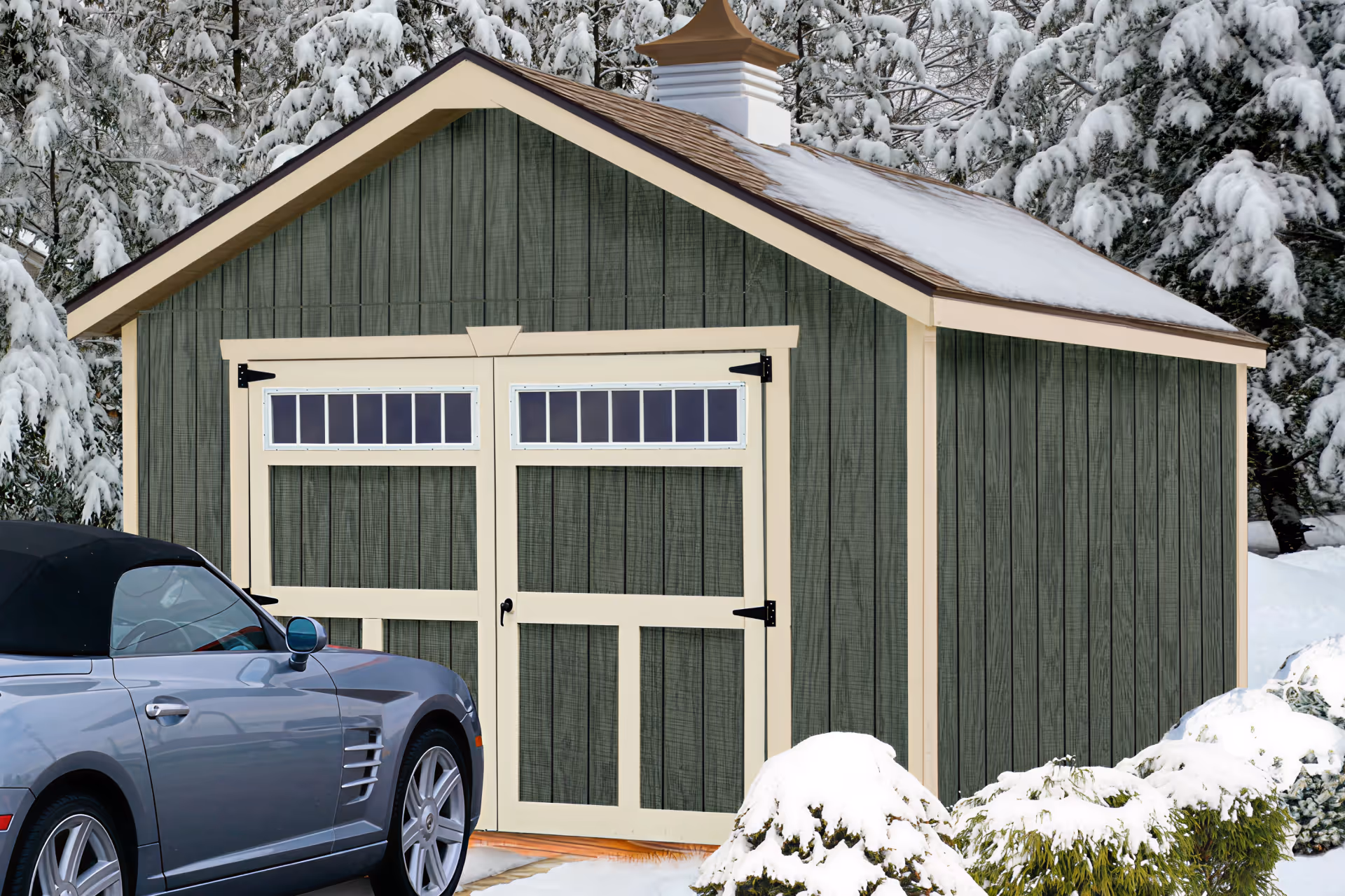 garage shed covered in snow with car in front of it