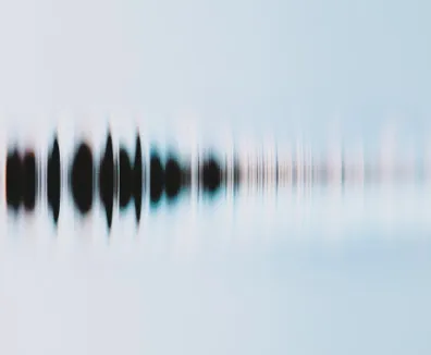 Abstract blurred soundwave pattern in black and blue tones on a light background.