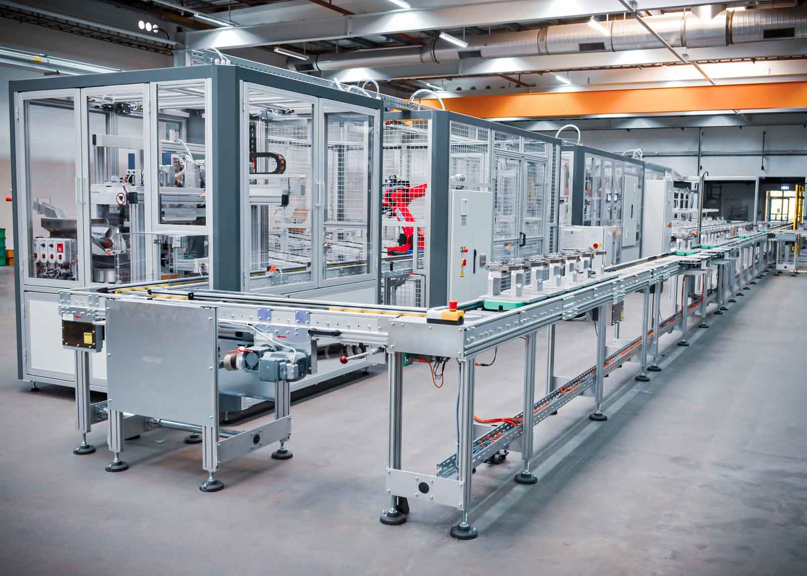 Verkettete Montageanlage zur vollautomatischen Herstellung von Kunststoffteilen mittels Spritzgussmaschinen und Montagezellen