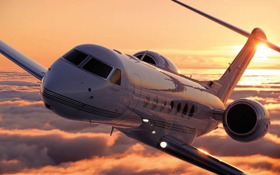 a plane flying above the clouds at sunset