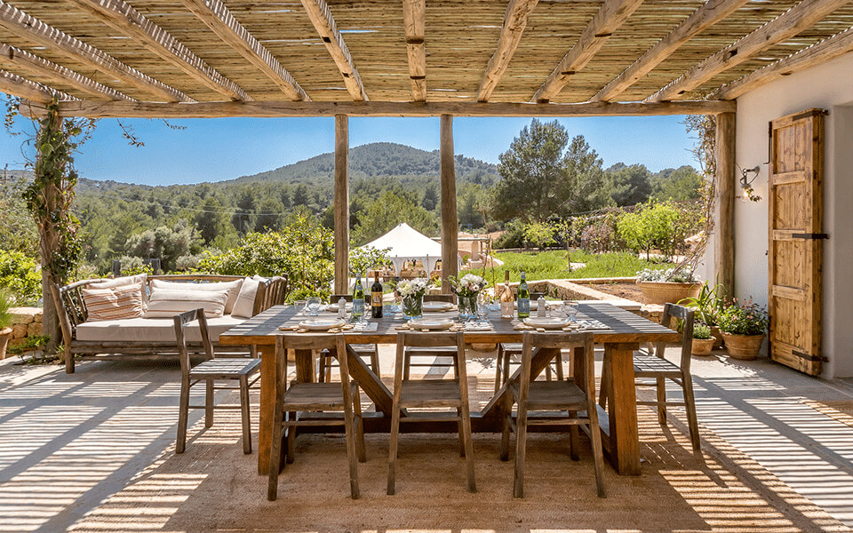 A covered patio with a table and chairs.