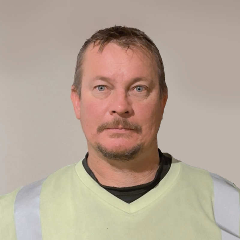 Mies keltaisessa heijastinliivissä neutraalilla taustalla.