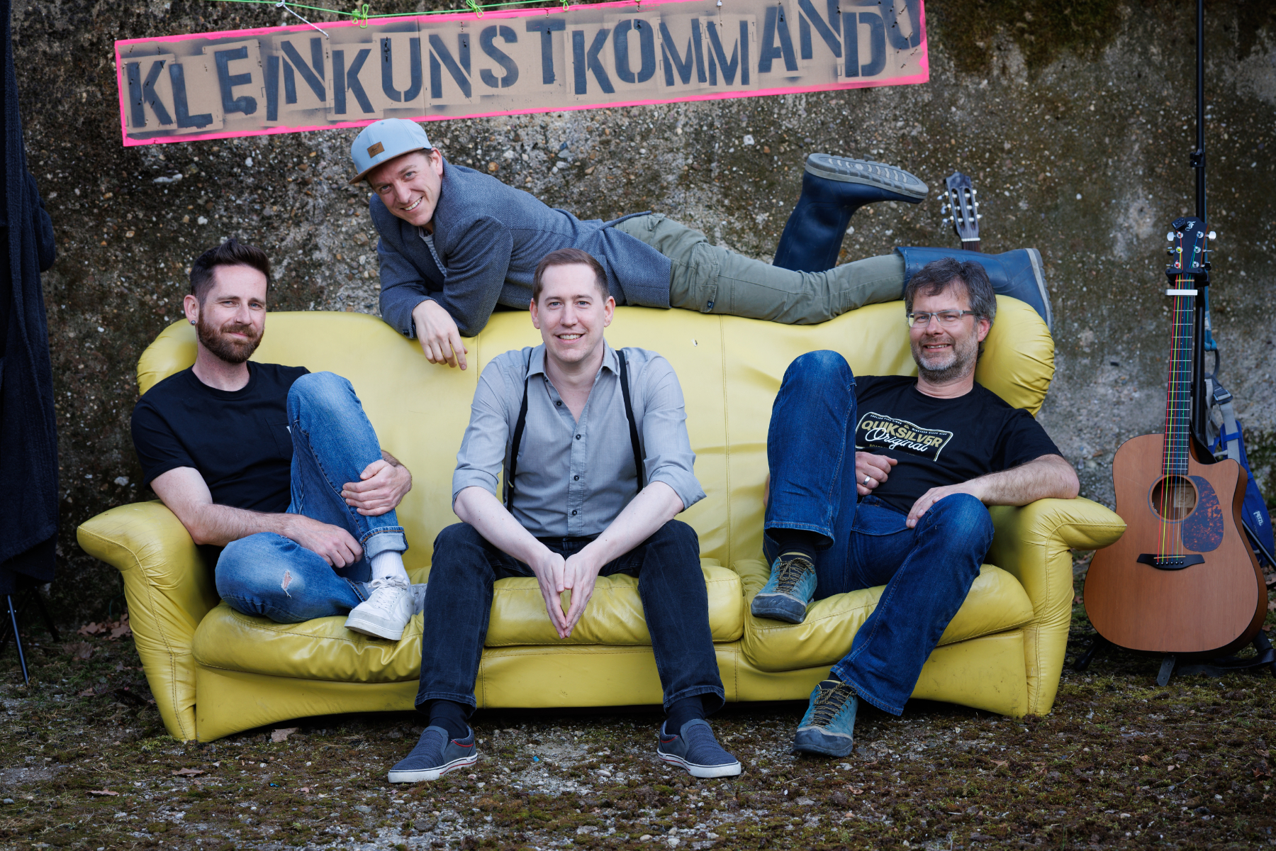 Band Kleinkunstkommando auf einem gelben Sofa vor einer Mauer