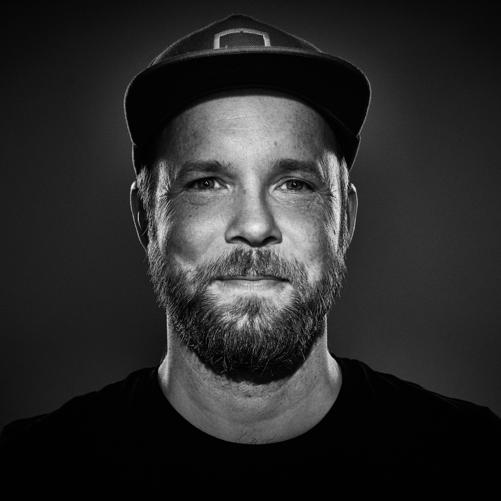 Ein Portrait von dem Künstler Quichotte mit einer schwarzen Kappe und einem schwarzen T-Shirt