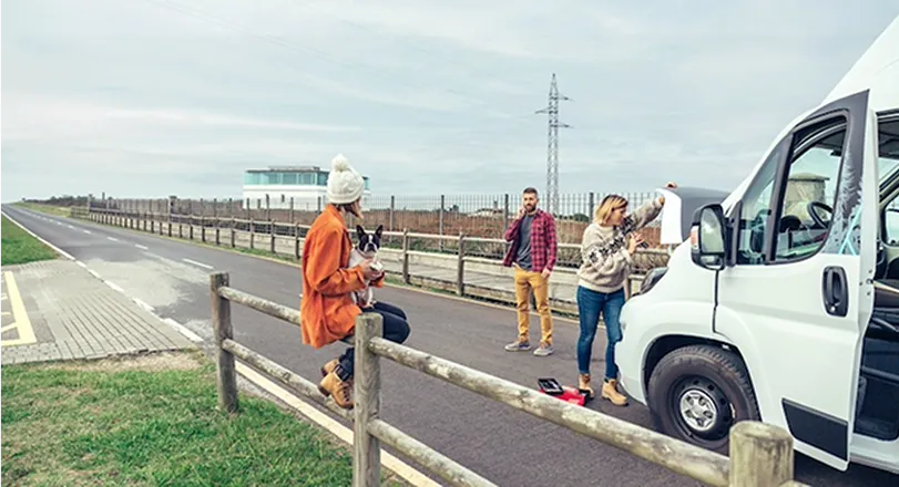 A group of people standing on the side of a road.