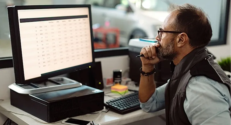 A man sitting in front of a computer on a desk.