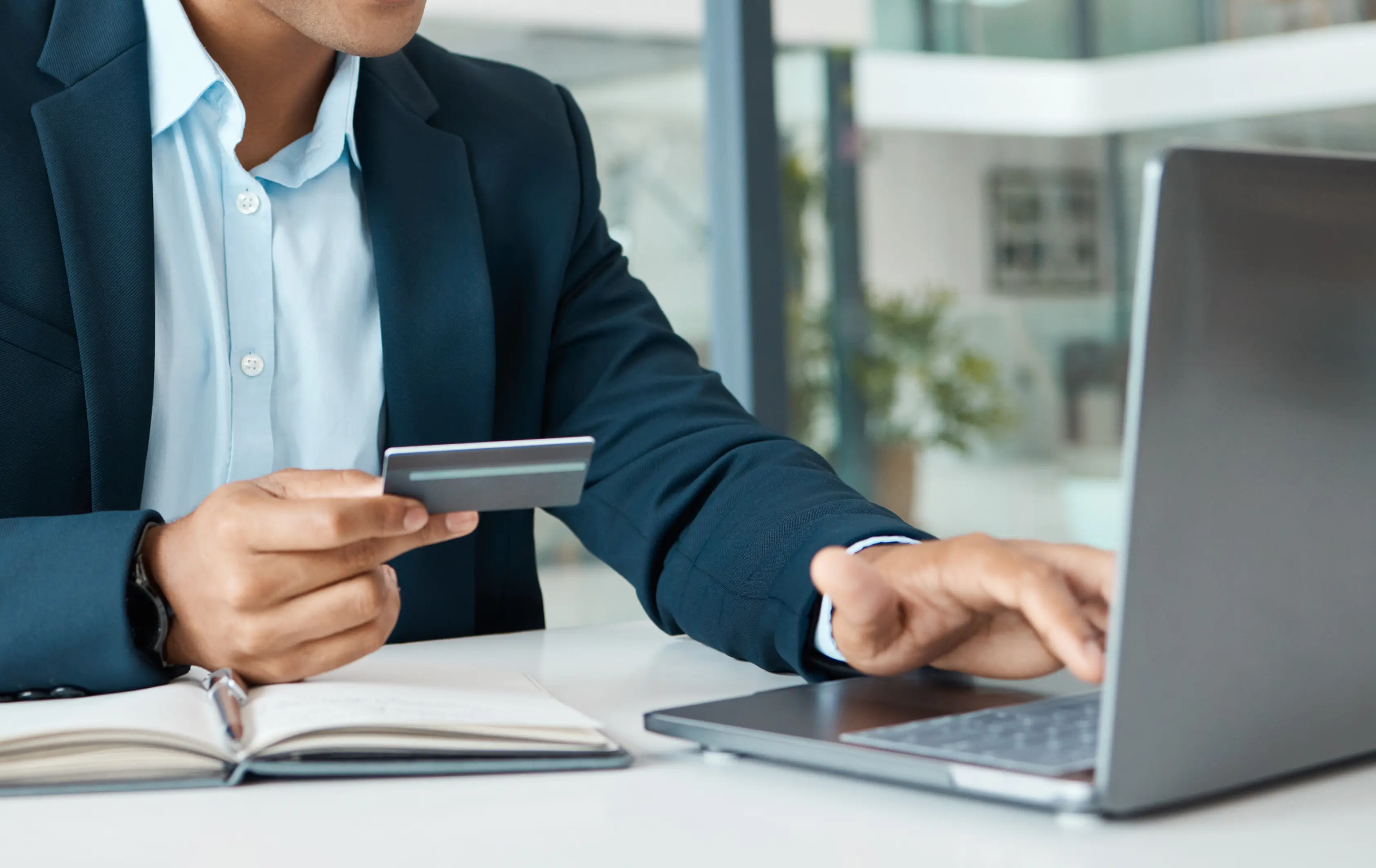 Man using his laptop and holding a credit card