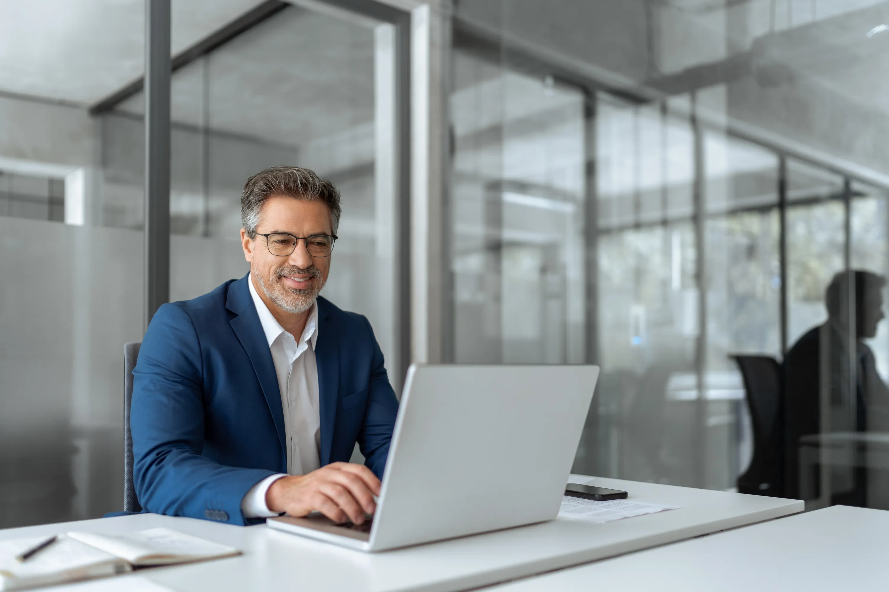 Person sitting in the office working on a laptop.
