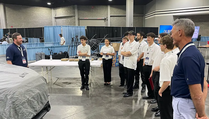 A group of people standing around a table.