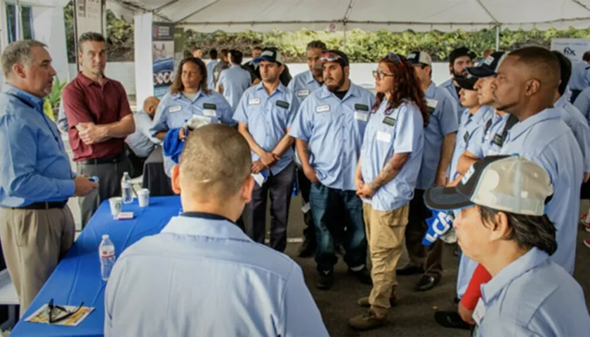 A group of people standing around a table.