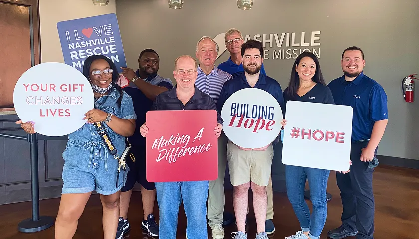 A group of people holding signs in a room.