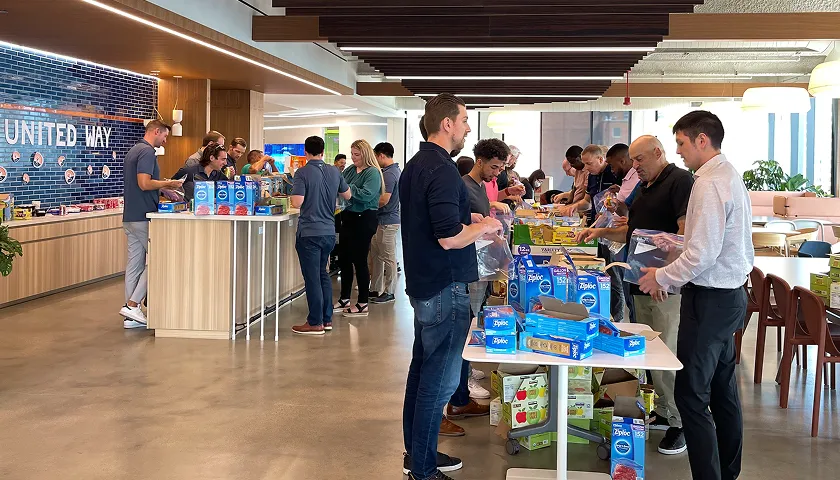 A group of people standing around a table.