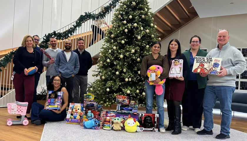 A group of people standing in front of a christmas tree.